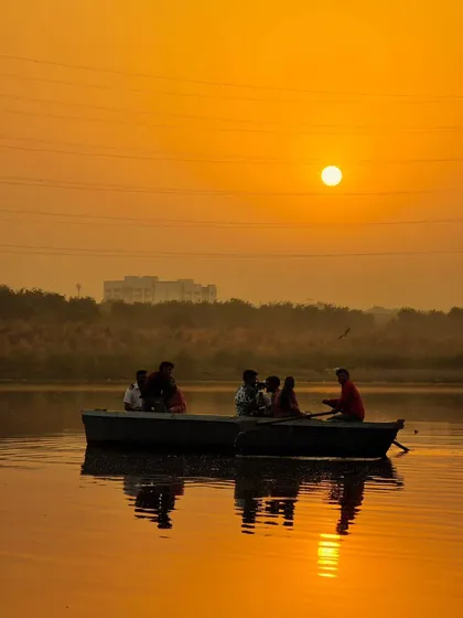 A family enjoying a boat ride at sunset. This silhouette against the golden sky is a perfect example of a peaceful and heartwarming travel memory.