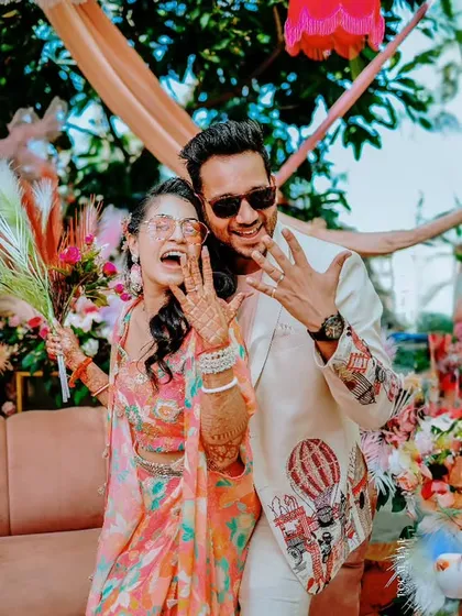 The couple shows off their new rings with excitement during a colorful and festive pre-wedding event.