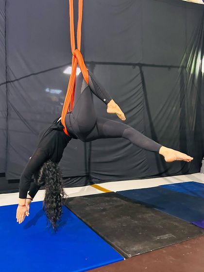 A deep stretch held with the support of the silks, allowing for greater flexibility and release than might be possible on the floor.