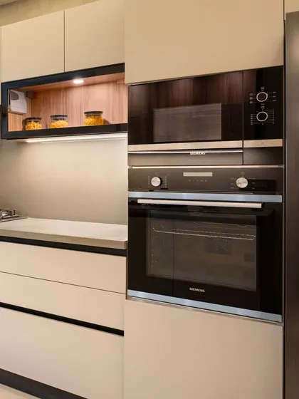 We prioritize ergonomics and functionality in our kitchen designs. Here, the built-in oven and microwave are placed at a convenient height, seamlessly integrated into the cabinetry for a clean, streamlined look.