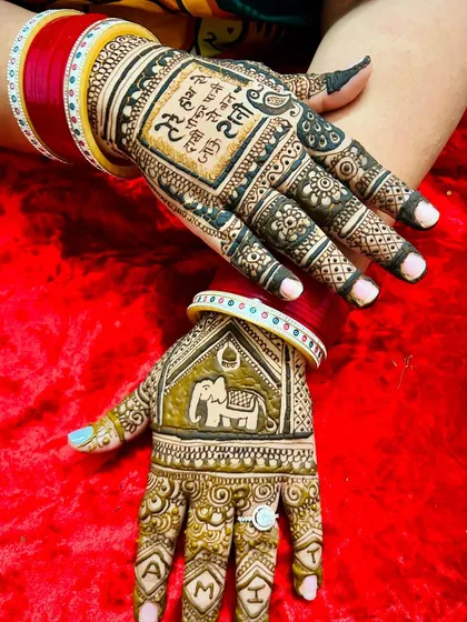 A stunning Karvachauth design with a Hindi verse on one palm and an elephant motif on the other. The client's red bangles beautifully complement the fresh henna.