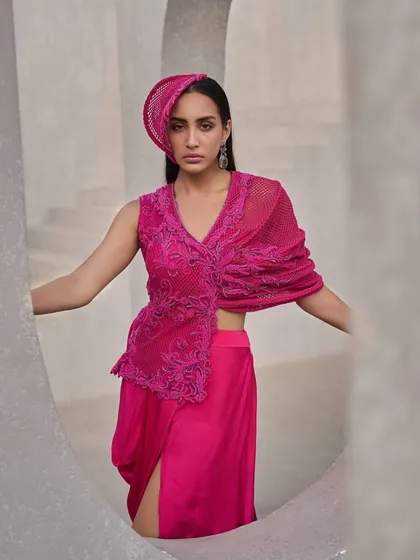 Fluid, fierce, and unapologetically bold. This hot pink two-piece set, with its sheer mesh and fine embroidery, flickers across layers like shifting light.