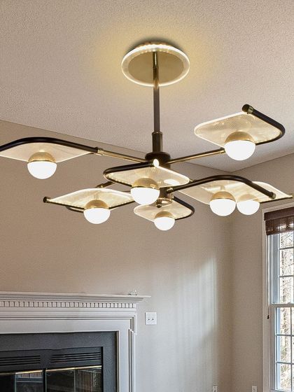 This chandelier looks wonderful in a room with natural elements like a wooden wall. The warm light from the globes complements the natural tones and creates a comfortable living space.