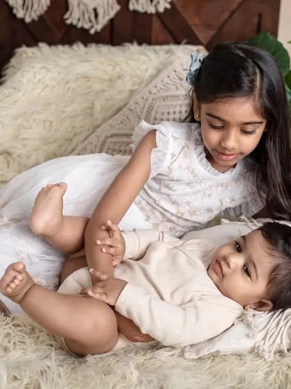 A playful moment with big sister looking after her baby brother. These candid interactions result in the most authentic and memorable sibling portraits.