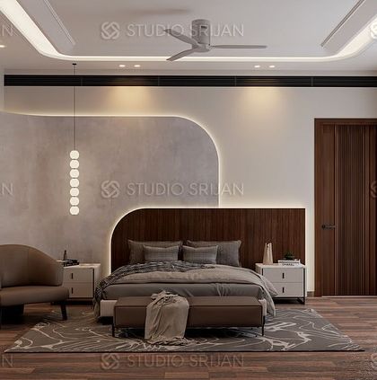 The bed in the same room is set against a feature wall with a curved, wood-paneled headboard and a textured grey finish, all highlighted by soft, indirect lighting.