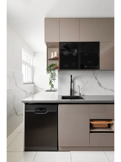 A sleek and functional kitchen layout with handleless cabinets for a minimalist look. The design incorporates a built-in dishwasher, a black sink and faucet for contrast, and a large-format tile backsplash with a marble pattern.