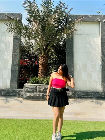 A full-length shot of the pink and black outfit. The sunny, outdoor setting makes the colors pop.