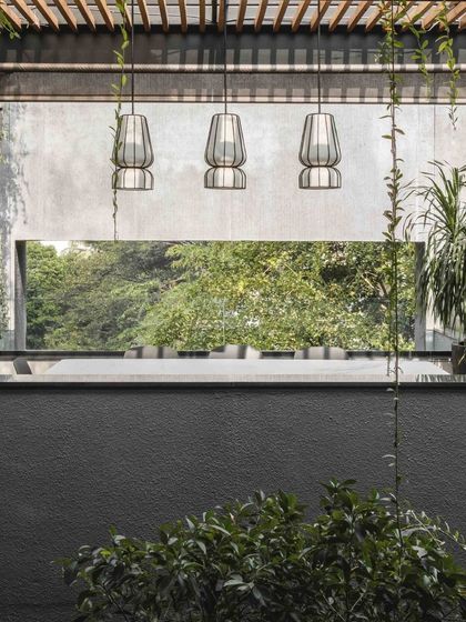 A play of light and shadows from the pergola creates a beautiful, shifting pattern over the covered dining area, enhancing the connection to the time of day.