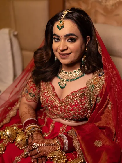 Our bride Shivali looking absolutely regal in a traditional red lehenga. We styled her dupatta as a veil, which is a great way to keep your hands free and enjoy the evening without any hassle.
