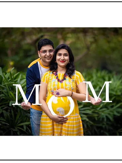 A creative portrait where the couple holds up letters spelling "MOM" around the baby bump.