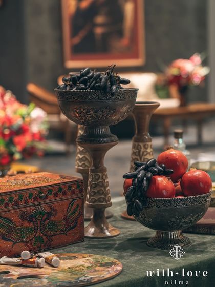 A tabletop still life with bowls of fruit, an artist's palette, and a vintage painted box. These curated details add layers of meaning and personality to the decor.