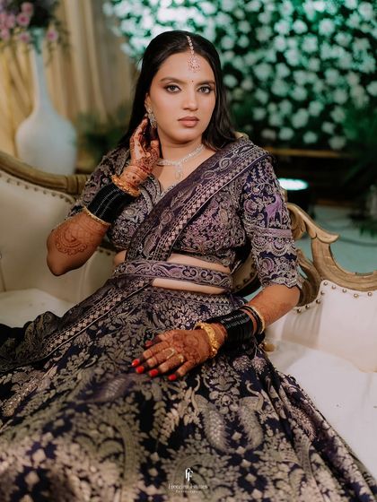 A close-up of the bride's hands and the intricate details of her reception lehenga.