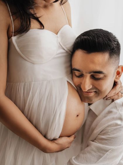 Listening for the baby's heartbeat. This is one of the sweetest poses for a dad-to-be. It’s an intimate and emotional moment, beautifully captured in a simple, modern style.