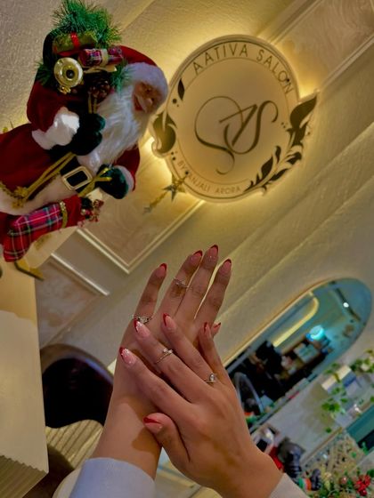 Showing off a beautiful set of red French tips against our salon's festive decor. It's the perfect nail look for any celebration.
