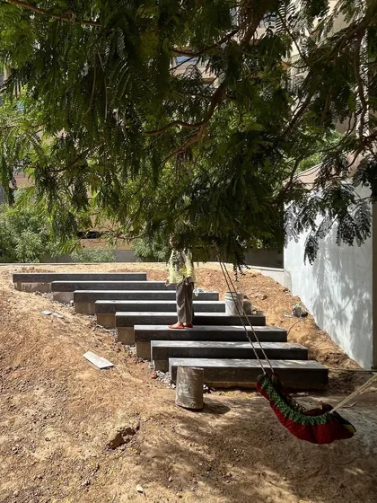 A site visit during the construction of the 'rising green' garden. This shows the hands-on process of building the stepped pathway and shaping the earth before the final planting and lawn installation.
