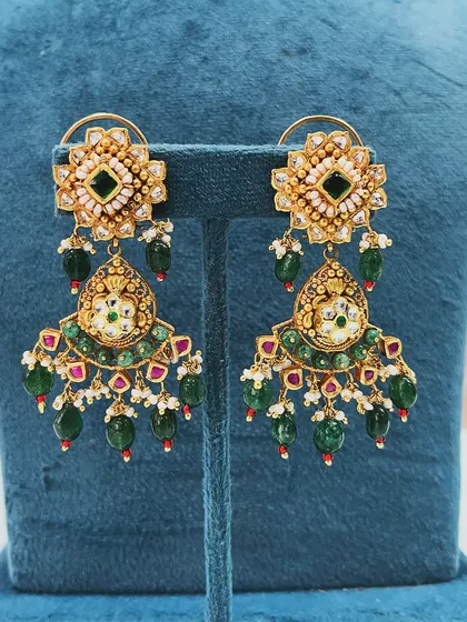 A close-up of the stunning earrings we created as part of a larger upcycle. By combining various old gold pieces, we were able to design these intricate, heavy earrings that perfectly match the new necklace.
