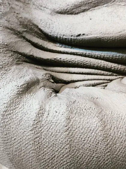 A close-up showing the texture and form of clay being worked by hand. Every piece starts with this fundamental, hands-on connection to the material.