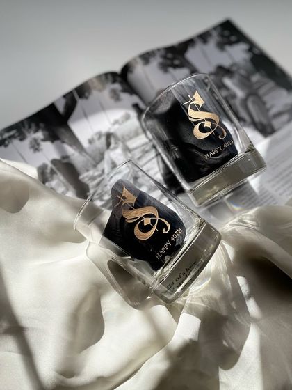A pair of whiskey glasses engraved with a large, ornate 'S' for a 40th birthday. Gifting men can be difficult, but a personalized whiskey glass is always a great choice.