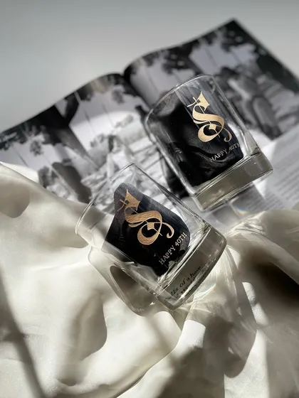 A pair of whiskey glasses engraved with a large, ornate 'S' for a 40th birthday. Gifting men can be difficult, but a personalized whiskey glass is always a great choice.