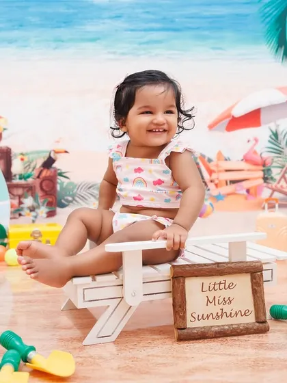 "Little Miss Sunshine" enjoying her beach-themed first birthday shoot.
