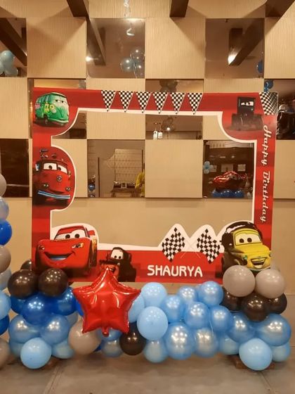 A Disney "Cars" themed photo booth frame. This setup is perfect for taking memorable pictures, with characters like Lightning McQueen and Mater.