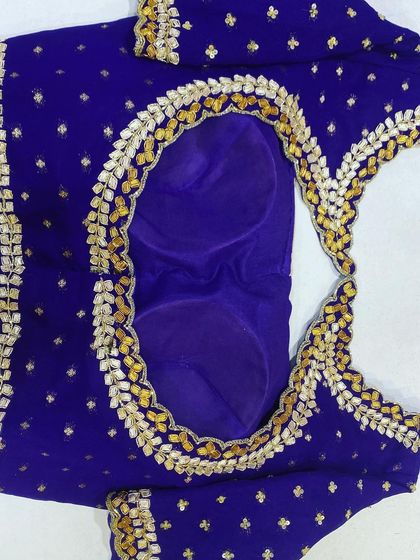 A royal blue blouse with a unique Gota Patti style leaf border around the neckline. The work is done in gold and silver for a traditional Rajasthani feel.