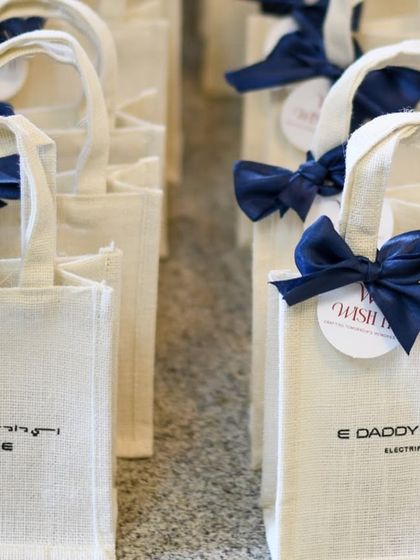 A close-up of the branded jute bags for our Dubai client. The deep blue ribbon and custom tag create an elegant and professional look.