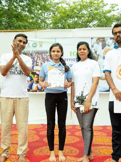 Another student being honored for her excellent performance during the Yoga Day event.