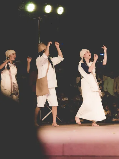 Three dancers on stage, their movements synchronized under the stage lights. This shot shows my ability to capture group performances while maintaining focus on individual expressions.