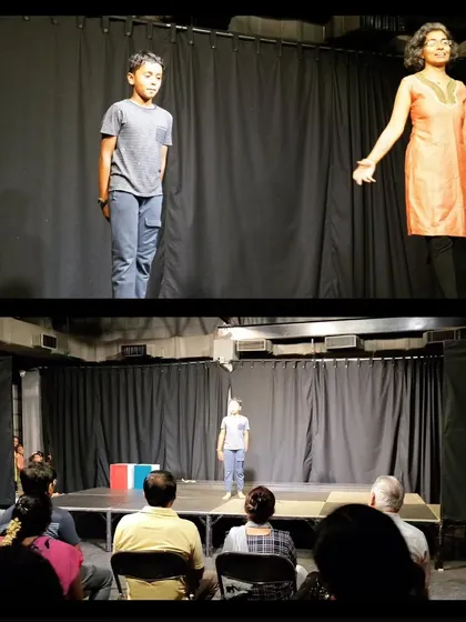 A teacher guides a young student through a monologue during a performance, showcasing the supportive learning environment at Vyoma.