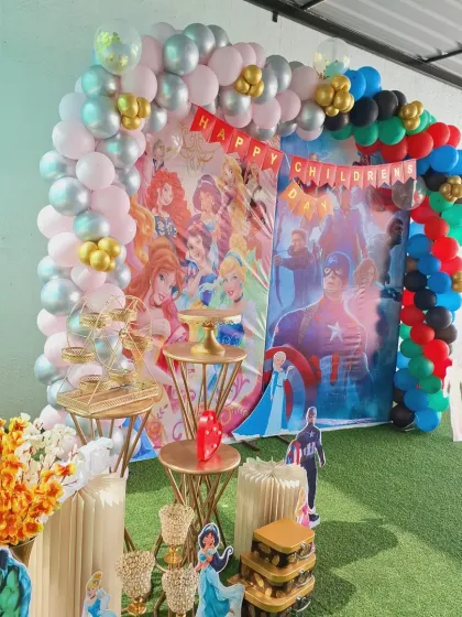 A closer look at the decorative elements, including multi-tiered stands for cakes or snacks and themed floral arrangements, all coordinated with the main backdrop.
