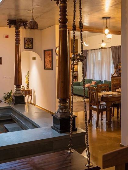A view from the courtyard into the dining and living areas, showing how antique wooden pillars and furniture create a rich, traditional atmosphere.