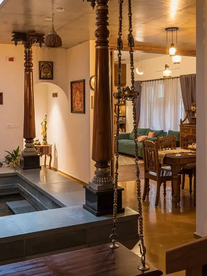 A view from the courtyard into the dining and living areas, showing how antique wooden pillars and furniture create a rich, traditional atmosphere.