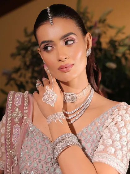 This image showcases the unique white henna design, which pairs beautifully with the cool tones of the monochrome pink makeup and diamond choker.