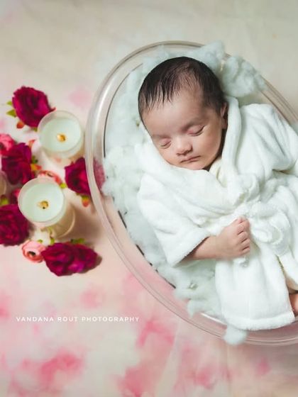 This close-up from the spa-themed newborn session shows the baby peacefully asleep. The focus is on their serene expression and the cozy white robe, making for a sweet and unique portrait.