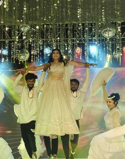 A duplicate of image 17, this is the hero shot of the performance, capturing the bride's triumphant lift with pyrotechnics for a truly cinematic finish.