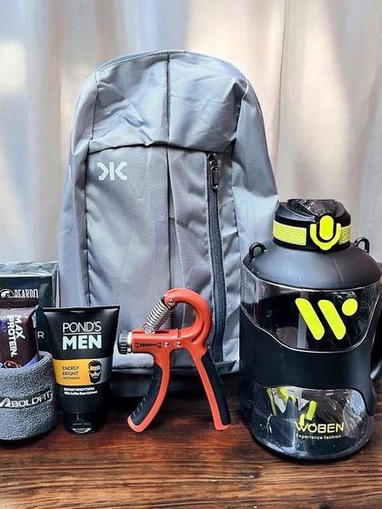 A fitness-themed gift hamper perfect for a health-conscious brother. This set includes a lightweight backpack, a large water gallon, a hand gripper, protein bars, and men's grooming products.