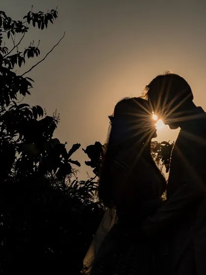 Love's silhouette against a setting sun. This creative portrait captures a quiet, intimate moment, turning a simple embrace into a piece of art that is both timeless and romantic.