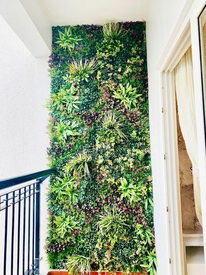 A full-height vertical garden panel makes a huge impact on this apartment balcony. The varied green textures create a stunning natural backdrop that enhances the view and provides a sense of privacy.