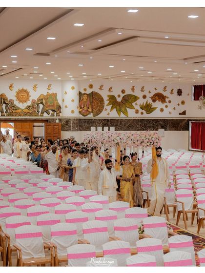 The bride's procession through the wedding hall, a moment of anticipation and beauty. The scale of the venue and the number of guests are captured in this wide shot.