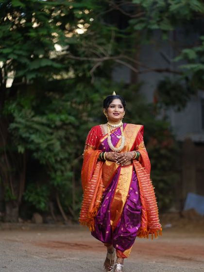 A candid shot of the bride walking, showcasing the grace and movement of the Nauvari saree. The makeup and hair are designed to complement this regal attire.