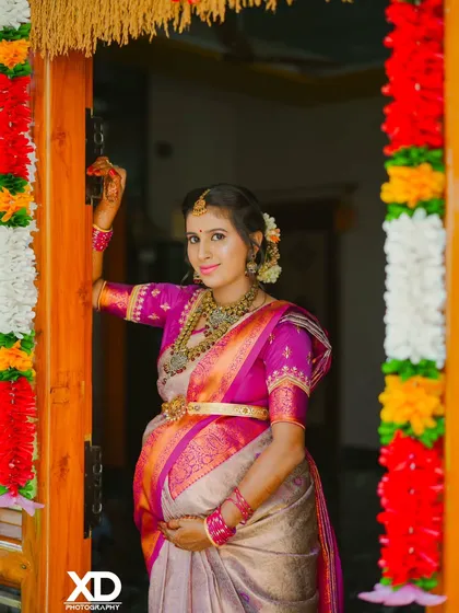 A welcoming portrait of the mother-to-be at the entrance, surrounded by festive decorations for her baby shower.