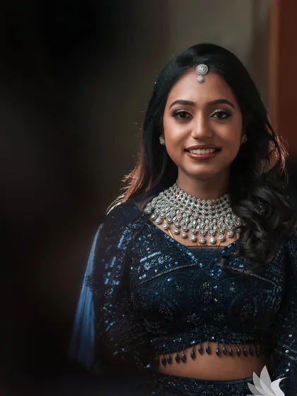 A stunning close-up portrait of Dr. Akshara. The lighting highlights her flawless makeup and the sparkle of her diamond jewellery.