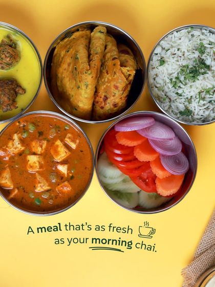 A meal that's as fresh as your morning chai. This veg tiffin features paneer matar, kadhi pakora, rice, and parathas.