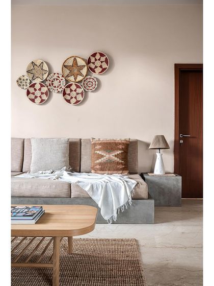 In this family entertainment room, I opted for a low, concrete-finished seating arrangement instead of a standard couch. This gives the space a casual, relaxed vibe, perfect for lounging. Woven wall baskets complete the earthy, boho look.