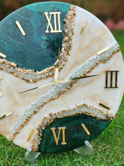 I design and create custom resin clocks that are both beautiful and functional. This geode-style clock features emerald green and pearly white pigments with gold accents, creating a luxurious piece of wall decor that looks like a natural stone formation.