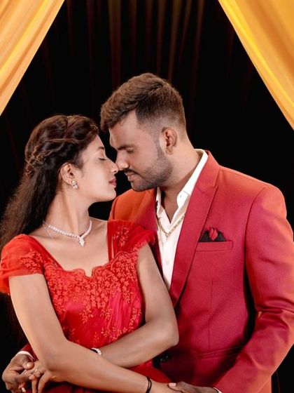 A close-up, romantic portrait in front of the golden-lit stage backdrop.