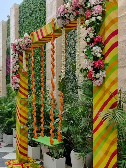 Another angle of the festive jhoola, framed by pillars decorated with floral arrangements. These swings are a central part of Teej celebrations and make for a beautiful photo opportunity.