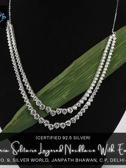 This stunning layered necklace is crafted with two rows of high-grade CZ solitaires, creating the look of a classic diamond necklace. It is made in pure 92.5 silver and is perfect for formal events.