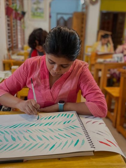 A student practices basic strokes, a fundamental step in mastering both watercolor and acrylics. Our classroom provides the space and guidance for this essential, focused work.